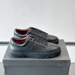 Zapatillas de cuero negro y marrón con logo embossado en la lateral