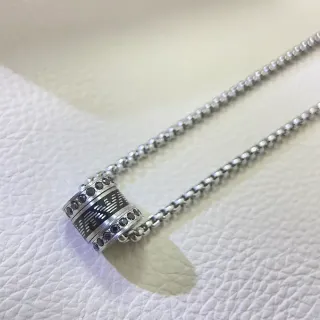 Collier argenté noir avec pendentif cylindrique rotatif incrusté d'émail