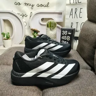 Adidas Chaussures de course à tige en knit noir et blanc avec branding de trois rayures