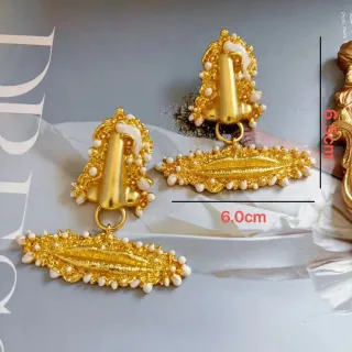 Brincos pendentes dourados inspirados no barroco, adornados com pérolas e com design escultórico
