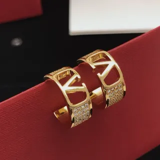 أقراط هووب كاف بلون ذهبي مع بلورات بافيه وشعار مفتوح