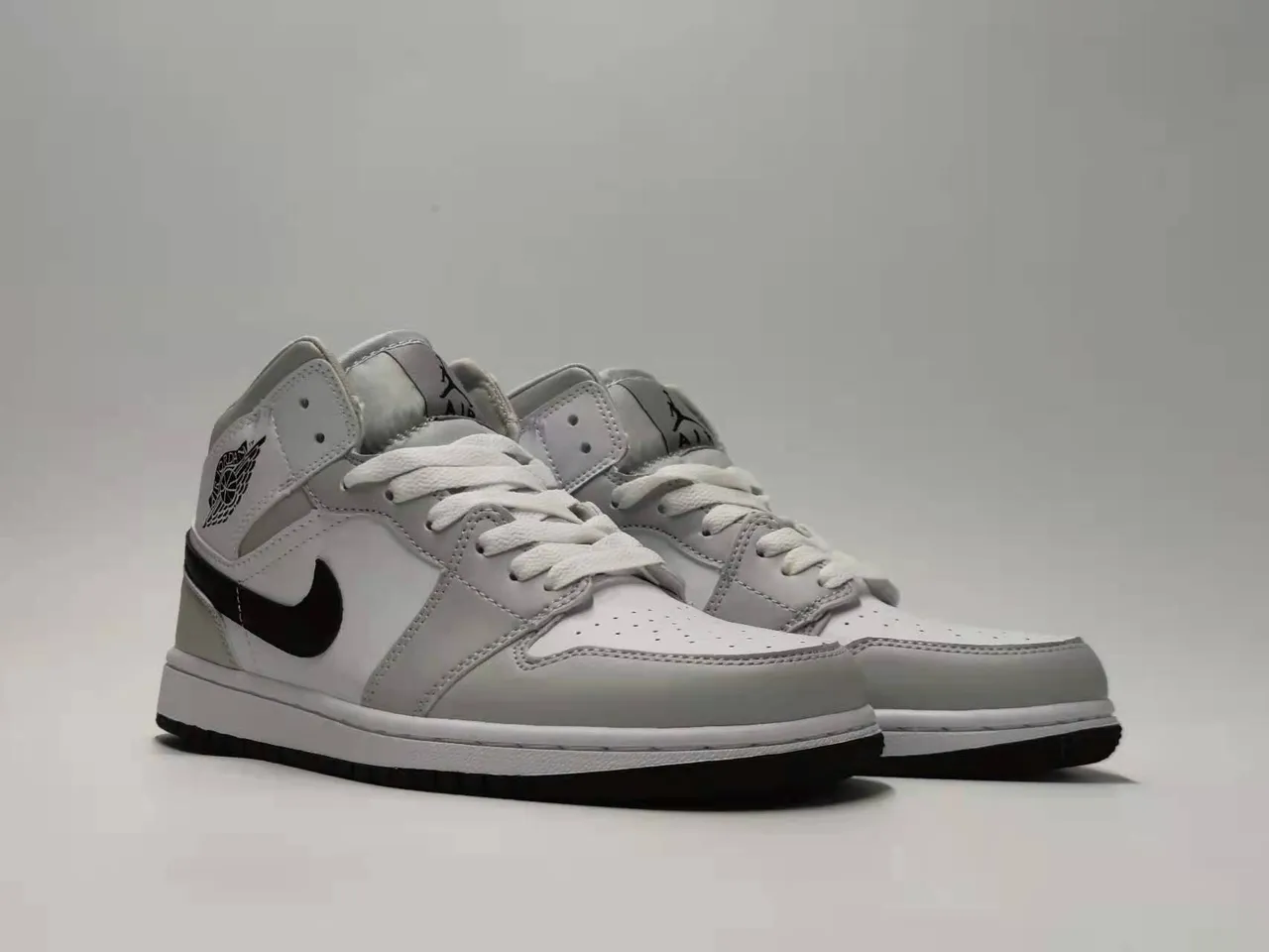 Tênis de basquete Air Jordan 1 Mid silhueta cinza e preta com painéis de couro e material sintético 4