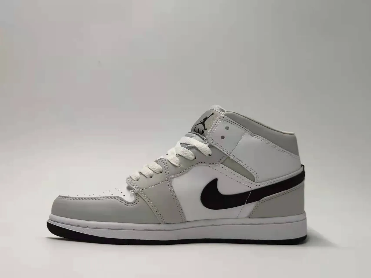 Tênis de basquete Air Jordan 1 Mid silhueta cinza e preta com painéis de couro e material sintético 6