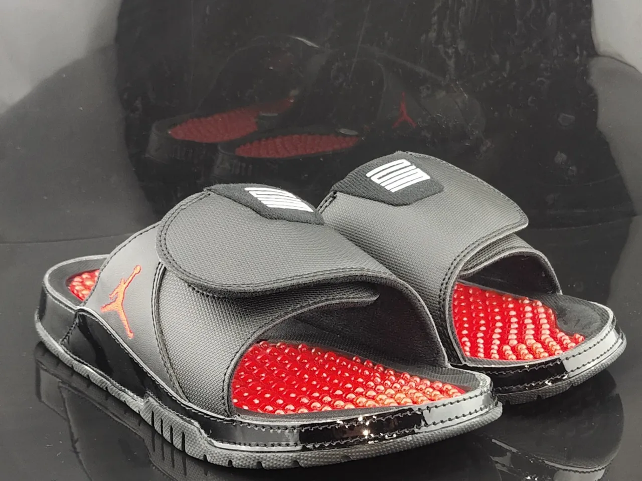 Pantoufles Air Jordan noir et rouge avec tige textile et assise plantaire à coussinets 3