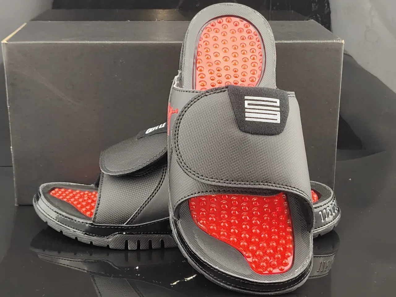 Pantoufles Air Jordan noir et rouge avec tige textile et assise plantaire à coussinets 4