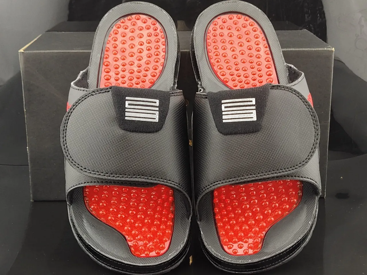 Pantoufles Air Jordan noir et rouge avec tige textile et assise plantaire à coussinets 5
