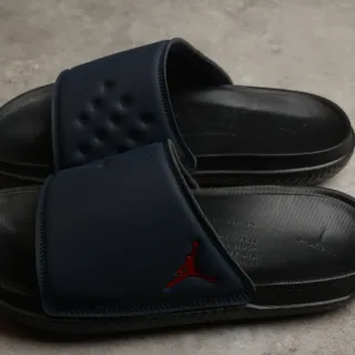 Chanclas Air Jordan Slide negro y rojo de tira única con plantilla moldeada