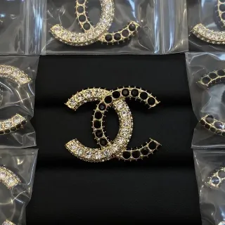 Chanel CC ब्रोच गोल्ड-टोन क्रिस्टल और ब्लैक स्टोन ब्रोचेस