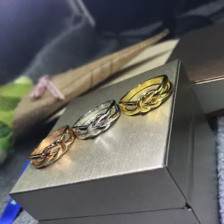 Anel com design de nó entrelaçado com acabamento metálico dourado e prateado