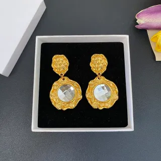 Brincos com centro de cristal facetado transparente em metal texturizado dourado
