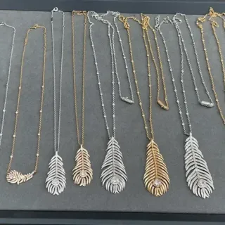 Collier avec pendentif en forme de plume pavé argent et or avec pierres