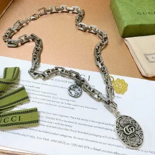 Collar Gucci cadena de eslabones ornamentada plateada y amarilla con GG Logo Charms