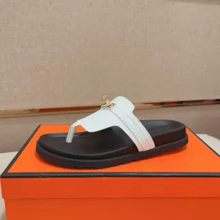 Hermès Oran Sandal सफेद काला चमड़ा T-Strap सोने के स्वर H-Link हार्डवेयर चप्पल