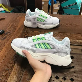 Adidas حذاء أسلوب حياة أبيض وأخضر مع midsole سميك وشبكي وتغطية تركيبية بناء