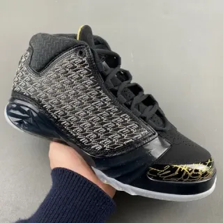 Tênis de basquete Air Jordan preto e dourado com cabedal em malha tecida e assinatura manuscrita
