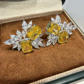 Brincos cluster com motivo floral e gemas amarelas e transparentes