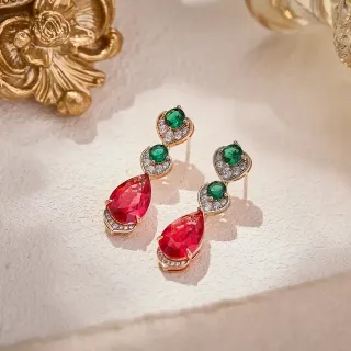 Brincos pendentes em tons dourados com gemas vermelhas e verdes