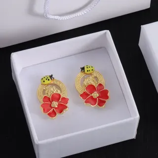 Brincos de esmalte vermelho floral e joaninha em tom dourado